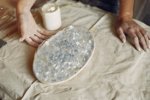 Young woman makes pottery in workshop