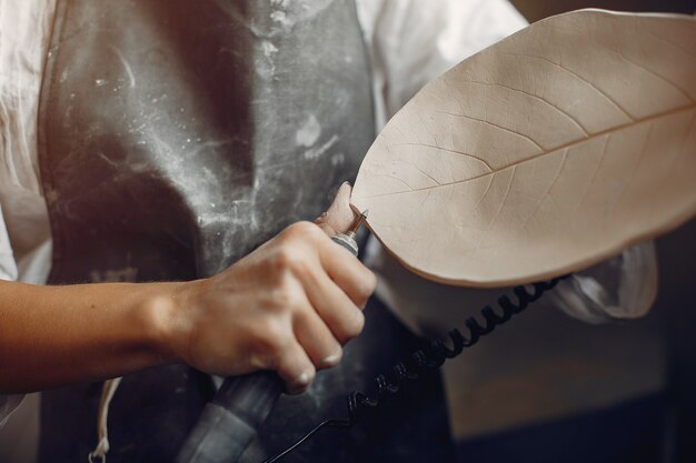 Young woman makes pottery in workshop