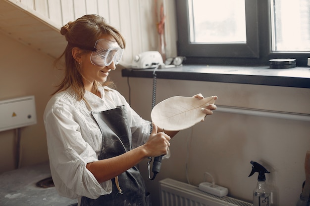 Free photo young woman makes pottery in workshop