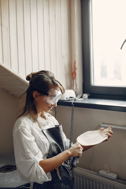 若い女性はワークショップで陶器を作る