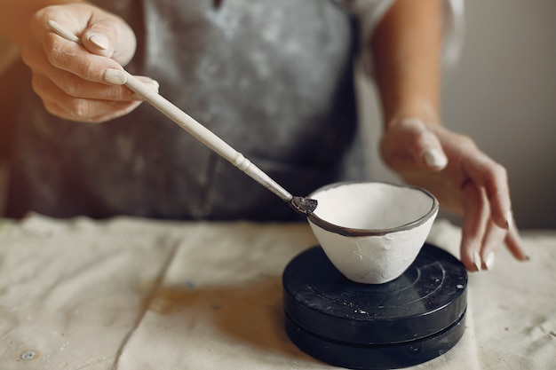 Young woman makes pottery in workshop