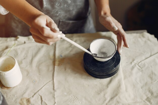 Young woman makes pottery in workshop