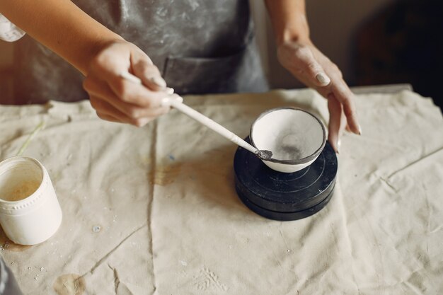 若い女性はワークショップで陶器を作る