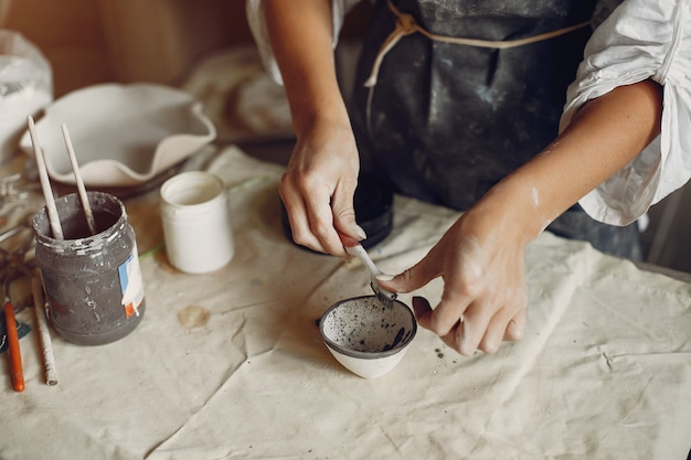 若い女性はワークショップで陶器を作る