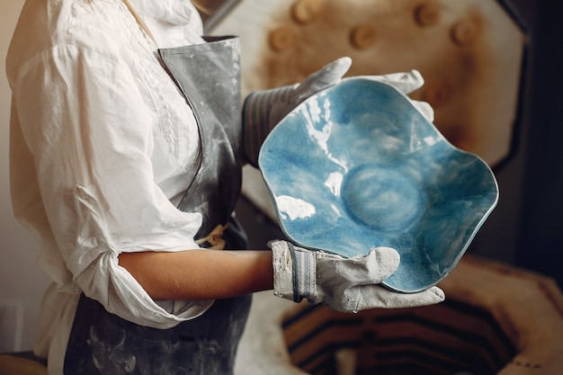 Young woman makes pottery in workshop