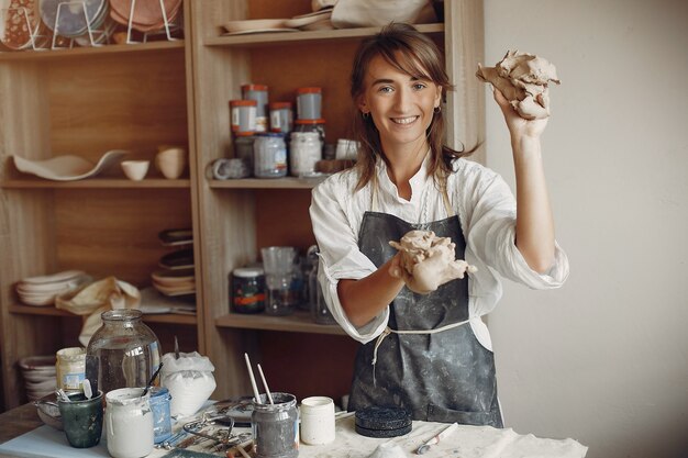 Young woman makes pottery in workshop