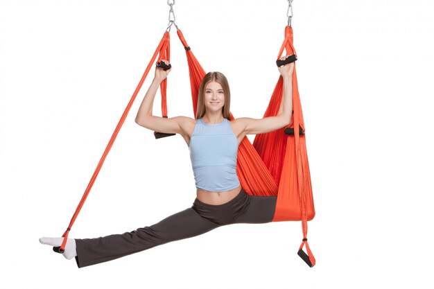 Young woman making antigravity yoga exercises in stretching twine