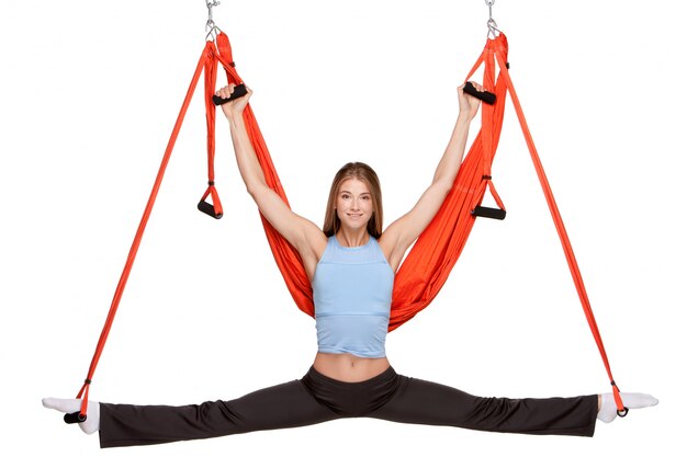 Young woman making antigravity yoga exercises in stretching twine