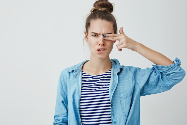 Young woman making finger-gun gesture