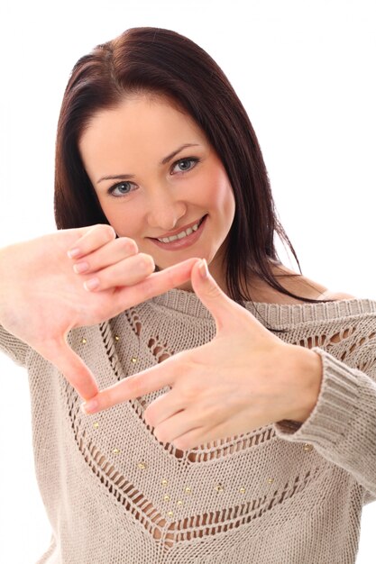 Молодая женщина делает рамку с пальцами