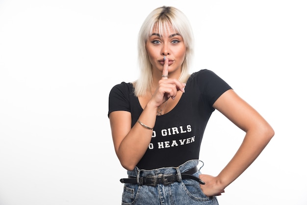 Free photo young woman making silence sign on white wall.