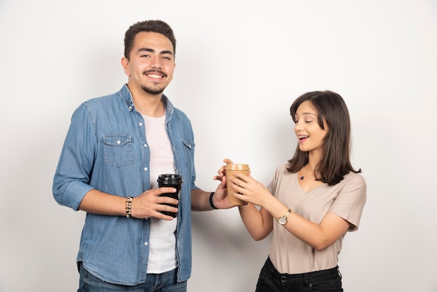 Young woman and man sharing coffee on white.