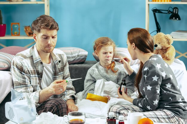 若い女性と自宅で病気の娘を持つ男。在宅治療。病気との戦い。医療ヘルスケア。家族の病気。冬、インフルエンザ、健康、痛み、親子関係、関係概念