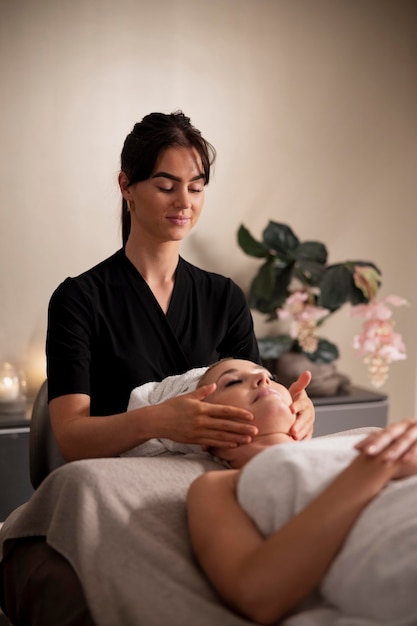 Free photo young woman massaging her client's face