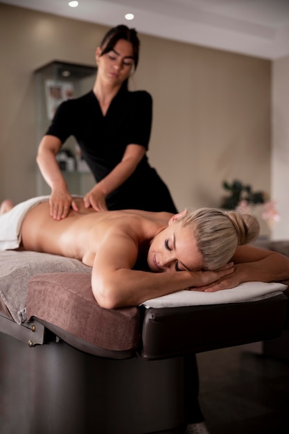 Foto gratuita giovane donna che massaggia il suo cliente