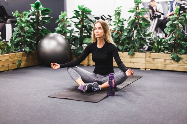Young woman meditating on exercise mat