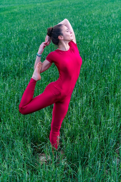 芝生のフィールドで瞑想する若い女性