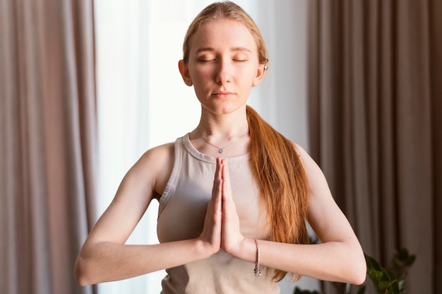 Free photo young woman meditating at home