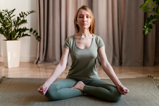 Giovane donna meditando a casa