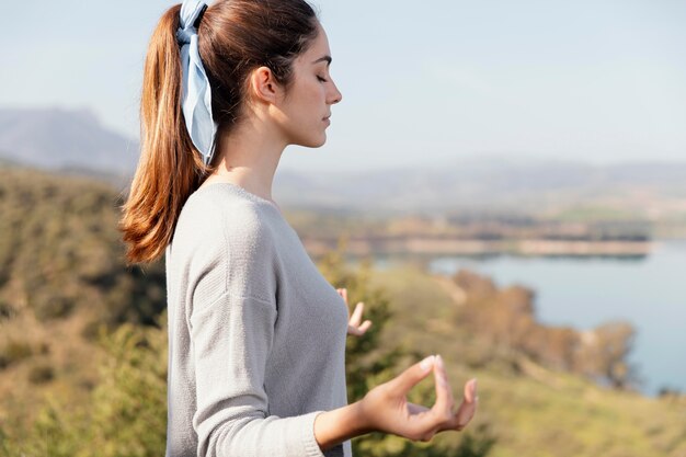 Молодая женщина медитирует на природе