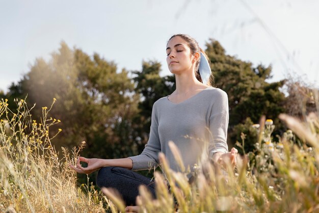 自然の中で瞑想する若い女性