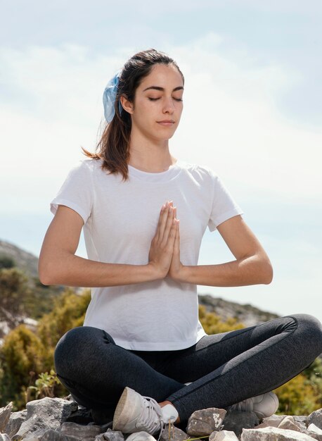 屋外で瞑想する若い女性