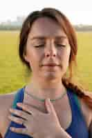 Free photo young woman meditating outdoors