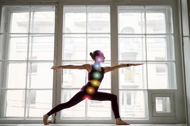 Free photo young woman meditating with chakras on her body