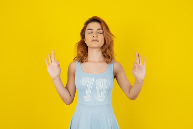 Young woman during meditation on yellow.