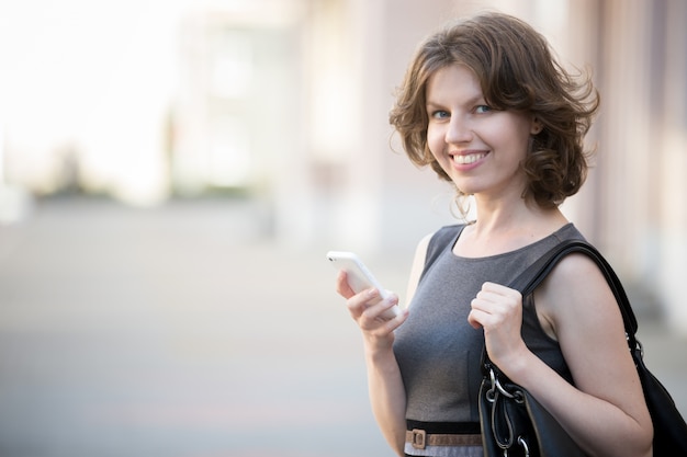 Young woman messaging on the street