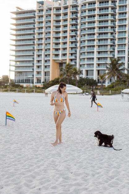 작은 강아지와 함께 마이애미 해변에 젊은 여자.