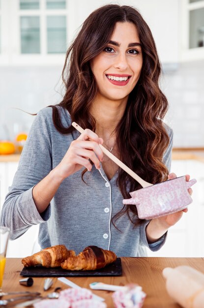 Young woman mixing sauce for croissants