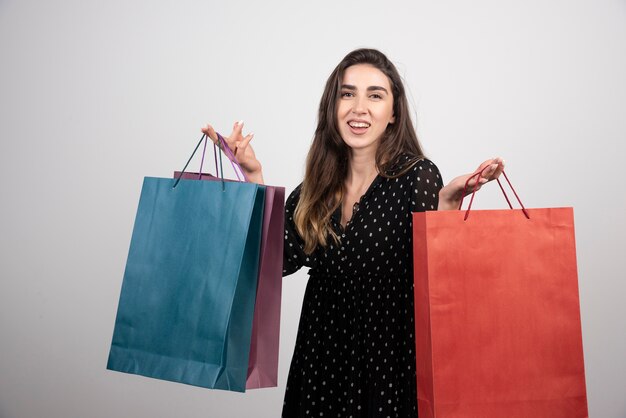 ショッピングバッグをたくさん運ぶ若い女性モデル