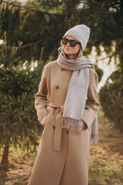 Young woman model dressed in warm coat outside in park