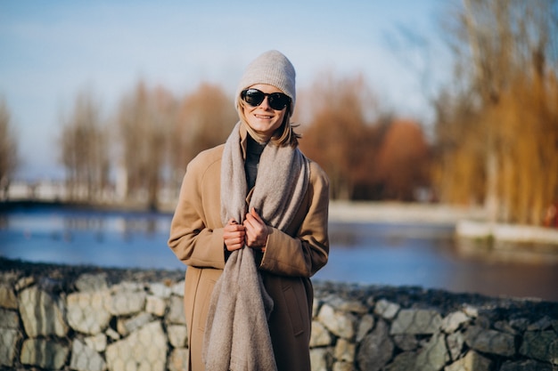 공원에서 외부 따뜻한 코트를 입은 젊은 여성 모델