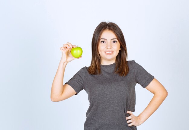 young woman model holding a green apple.