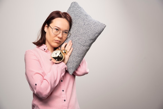 Young woman model holding a pillow on a white background. High quality photo