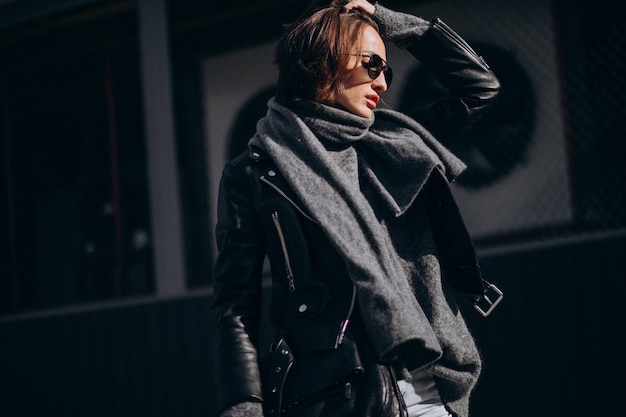 Модель молодой женщины в кожаной куртке вне улицы