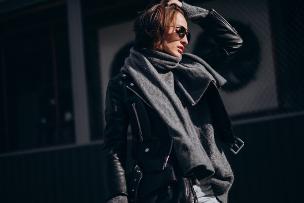 Young woman model in leather jacket outside the street