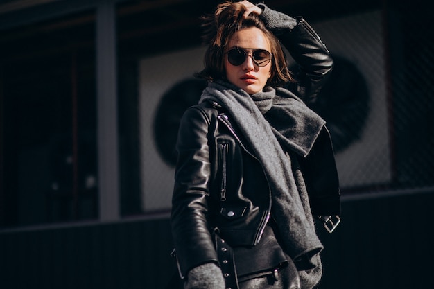 Модель молодой женщины в кожаной куртке вне улицы
