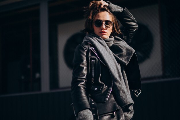 Young woman model in leather jacket outside the street