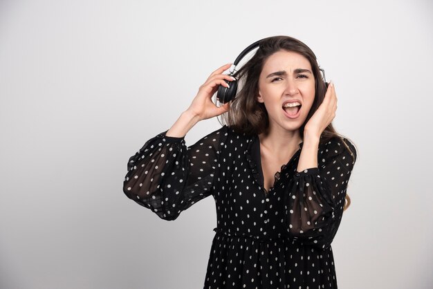 Young woman model listening music in headphones 