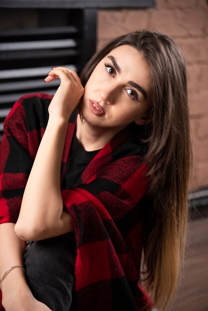 Young woman model posing with checkered plaid near Christmas balls.