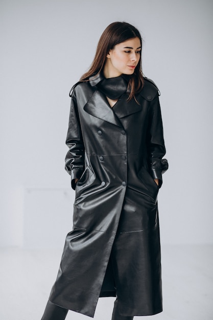 Young woman model wearing long black leather coat