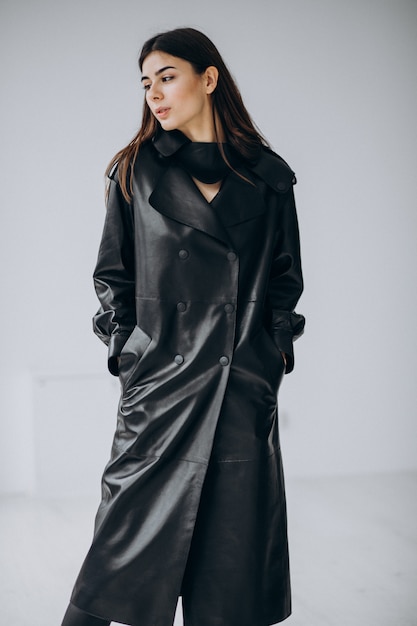 Young woman model wearing long black leather coat