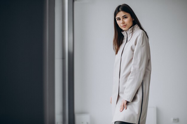 Young woman model wearing long gray coat