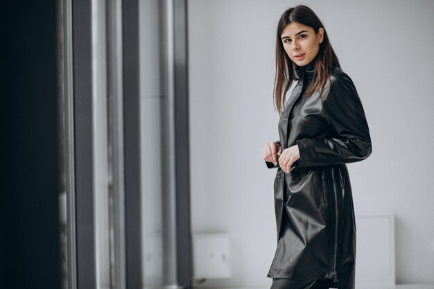 Young woman model wearing long leather coat