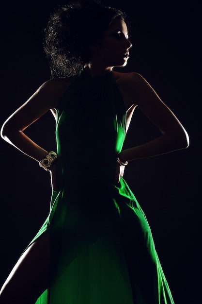 young woman model with green dress on darkness