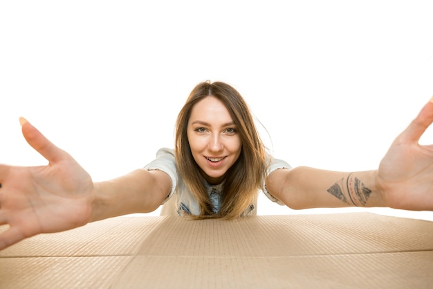 Young woman opening the biggest postal package isolated on white