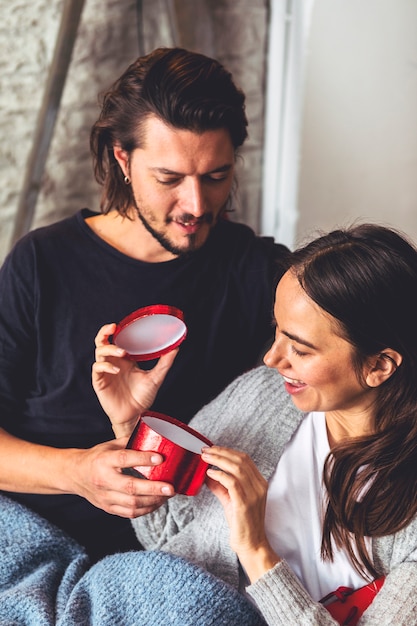 Young woman opening small red gift box